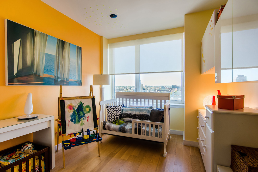 Design ideas for a small contemporary gender-neutral kids' playroom for kids 4-10 years old in New York with yellow walls and light hardwood floors.