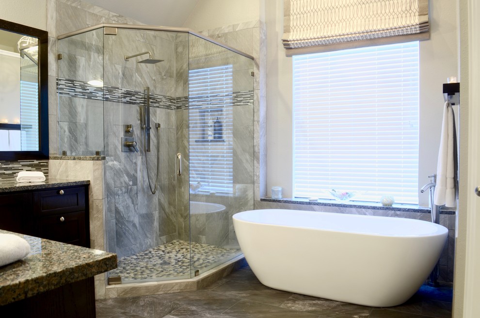 Inspiration for a large transitional master bathroom in Dallas with shaker cabinets, dark wood cabinets, a freestanding tub, a corner shower, a two-piece toilet, gray tile, porcelain tile, grey walls, porcelain floors, an undermount sink and granite benchtops.