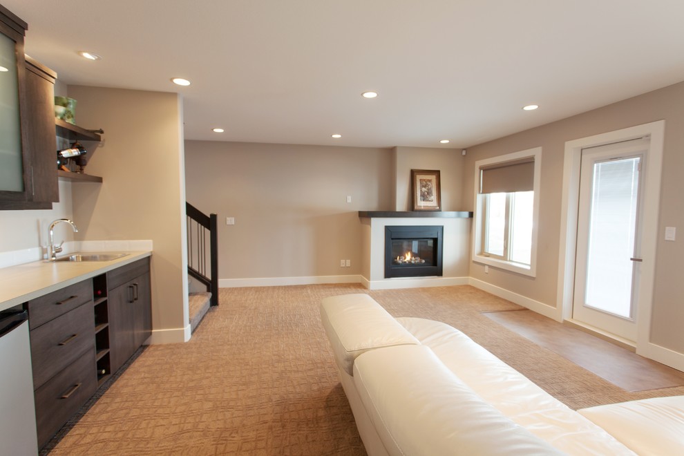 Inspiration for a large modern walk-out basement in Calgary with beige walls, carpet and a standard fireplace.