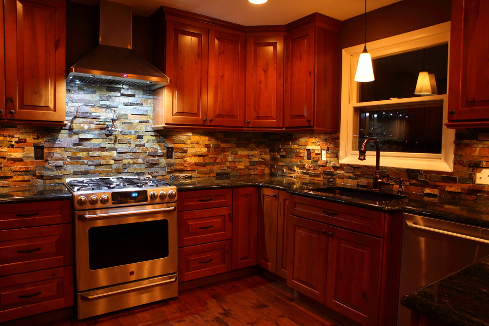 Example of a small mountain style u-shaped eat-in kitchen design with a single-bowl sink, raised-panel cabinets, medium tone wood cabinets, granite countertops, multicolored backsplash, stone slab backsplash, stainless steel appliances and no island
