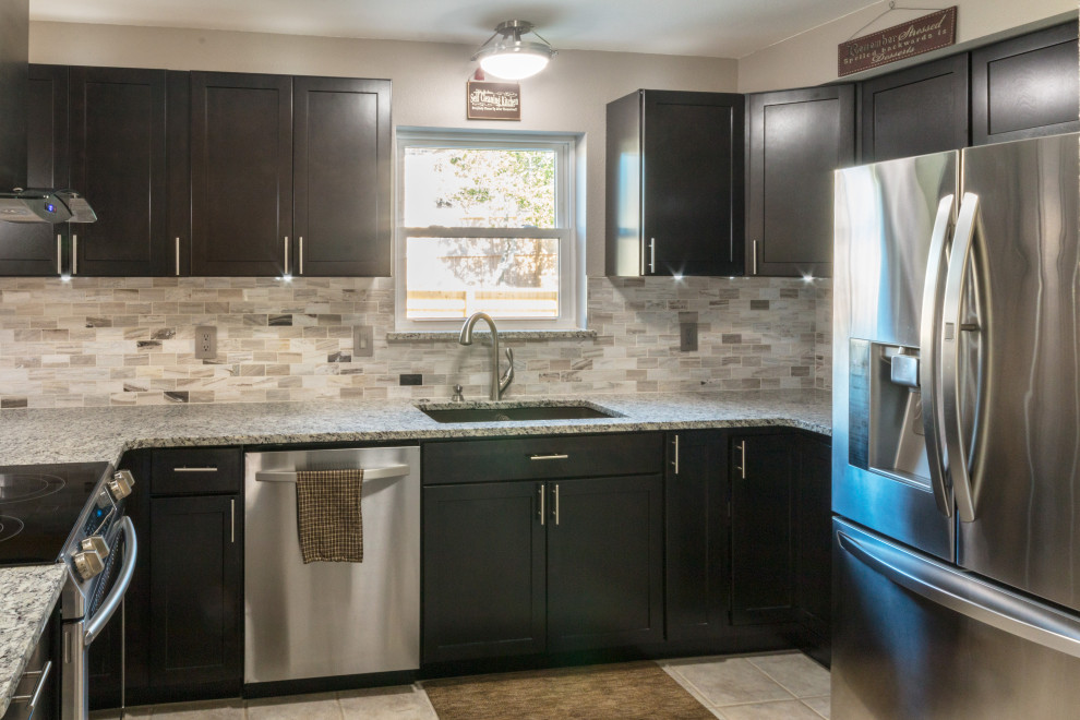 Eat-in kitchen - mid-sized u-shaped ceramic tile and beige floor eat-in kitchen idea with an undermount sink, shaker cabinets, black cabinets, granite countertops, glass tile backsplash, stainless steel appliances, an island and white countertops