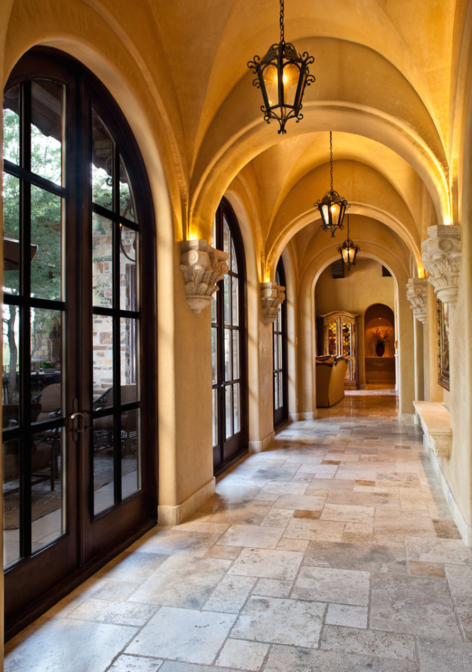 Expansive traditional hallway in Phoenix with brown walls and travertine floors.