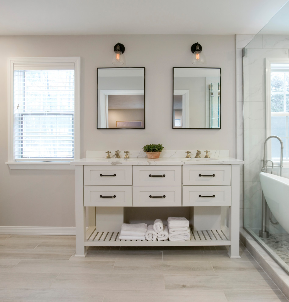 Photo of a large country master wet room bathroom in Boston with furniture-like cabinets, white cabinets, a freestanding tub, a one-piece toilet, white tile, porcelain tile, beige walls, wood-look tile, an undermount sink, engineered quartz benchtops, beige floor, an open shower, white benchtops, a double vanity and a freestanding vanity.