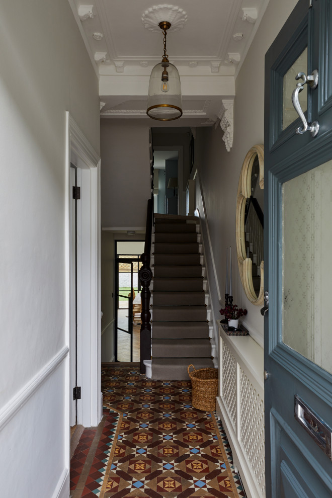На фото: входная дверь в классическом стиле с серыми стенами, одностворчатой входной дверью, синей входной дверью и разноцветным полом