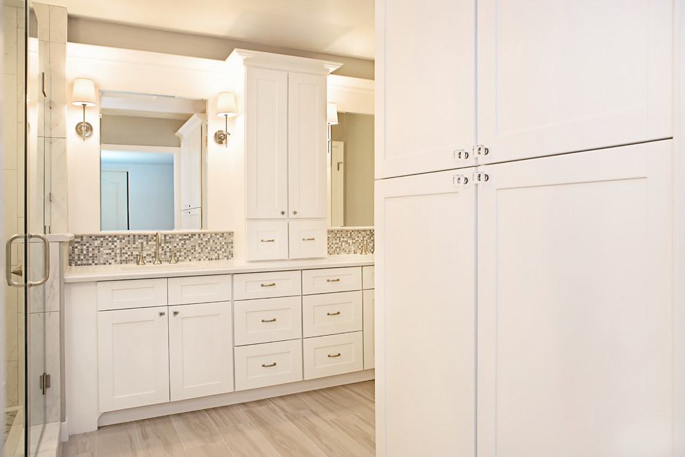 Inspiration for a mid-sized transitional master gray tile and porcelain tile porcelain tile drop-in bathtub remodel in Phoenix with an undermount sink, shaker cabinets, white cabinets, solid surface countertops, a two-piece toilet and gray walls