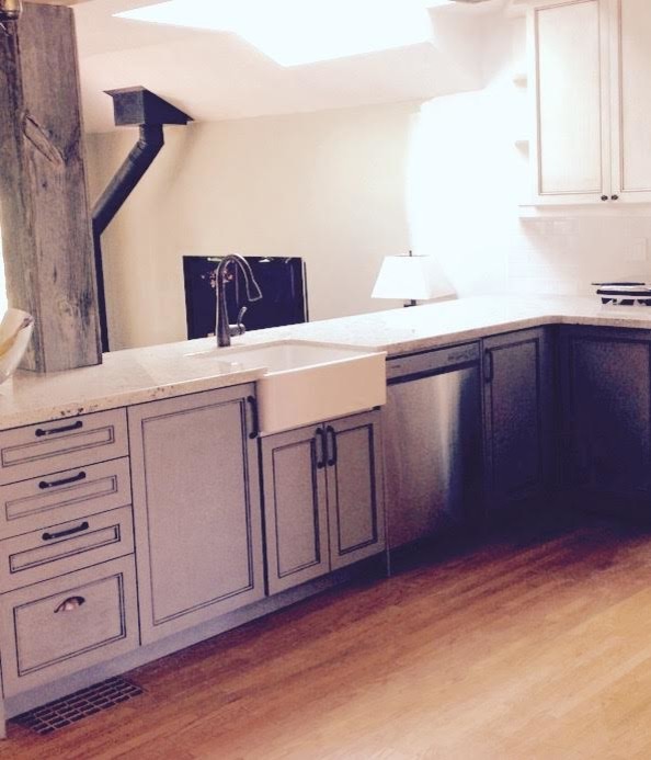 Mid-sized mountain style u-shaped light wood floor open concept kitchen photo in Toronto with a farmhouse sink, recessed-panel cabinets, distressed cabinets, granite countertops, white backsplash, stainless steel appliances and a peninsula