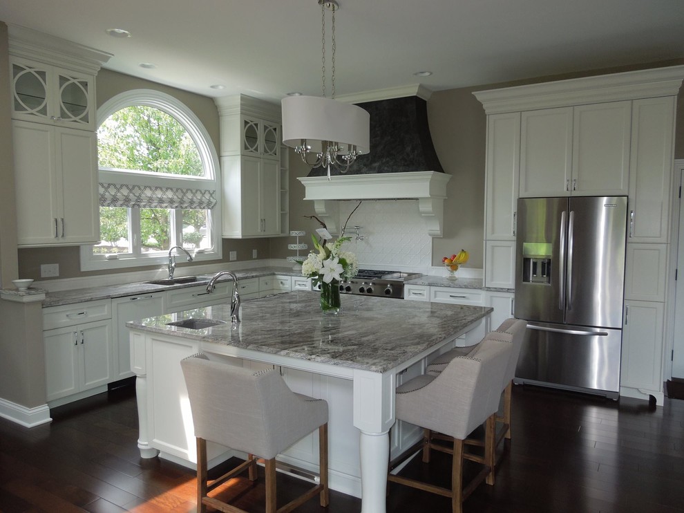 Open concept kitchen - large l-shaped dark wood floor open concept kitchen idea with a double-bowl sink, recessed-panel cabinets, white cabinets, granite countertops, white backsplash, ceramic backsplash, stainless steel appliances and an island