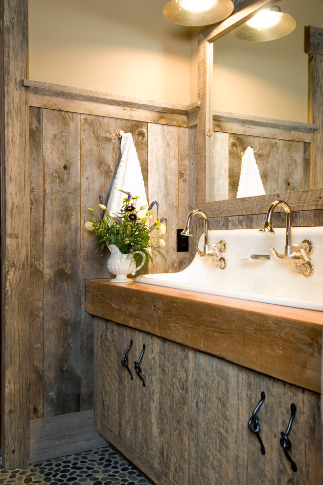 This is an example of a country bathroom in Other with a trough sink, flat-panel cabinets and distressed cabinets.