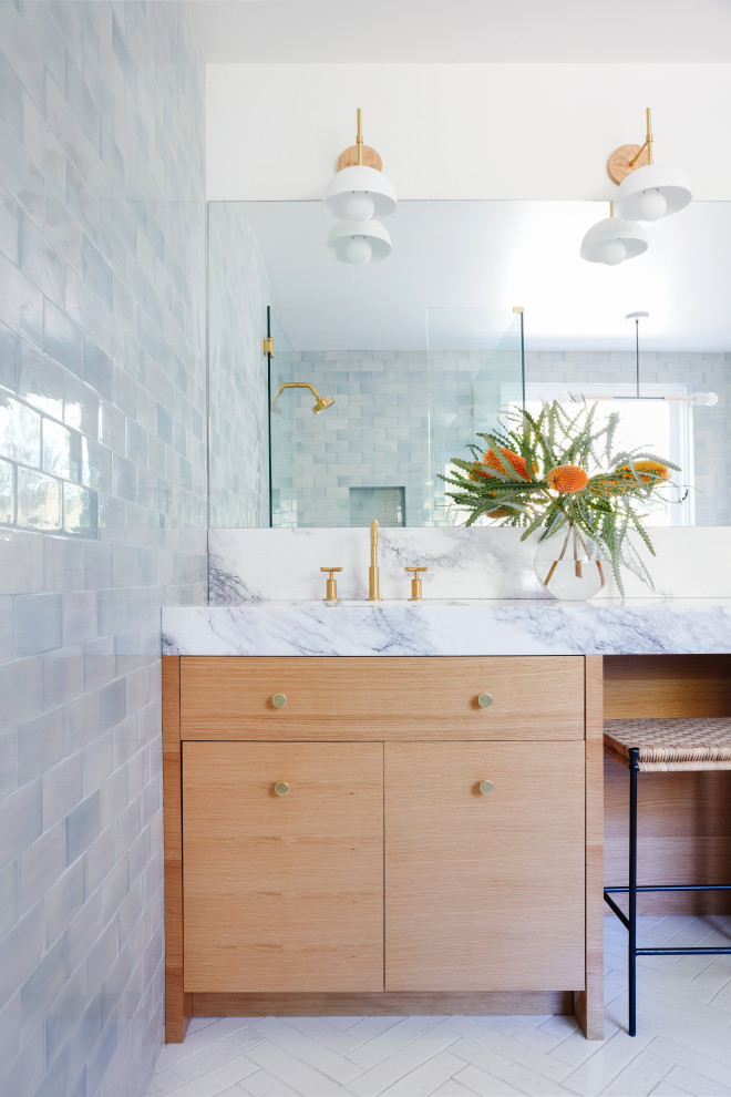 На фото: главная ванная комната среднего размера в стиле модернизм с плоскими фасадами, светлыми деревянными фасадами, синей плиткой, керамической плиткой, мраморной столешницей, белой столешницей, тумбой под две раковины и встроенной тумбой