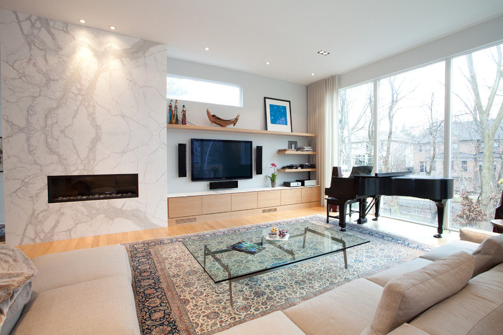 This is an example of a mid-sized contemporary open concept living room in Toronto with a music area, medium hardwood floors, a ribbon fireplace and a wall-mounted tv.