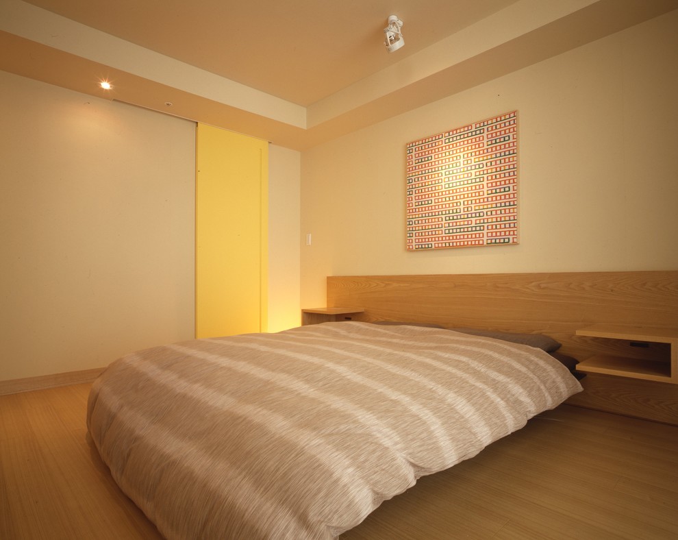 Contemporary guest bedroom in Tokyo with beige walls, light hardwood flooring and no fireplace.