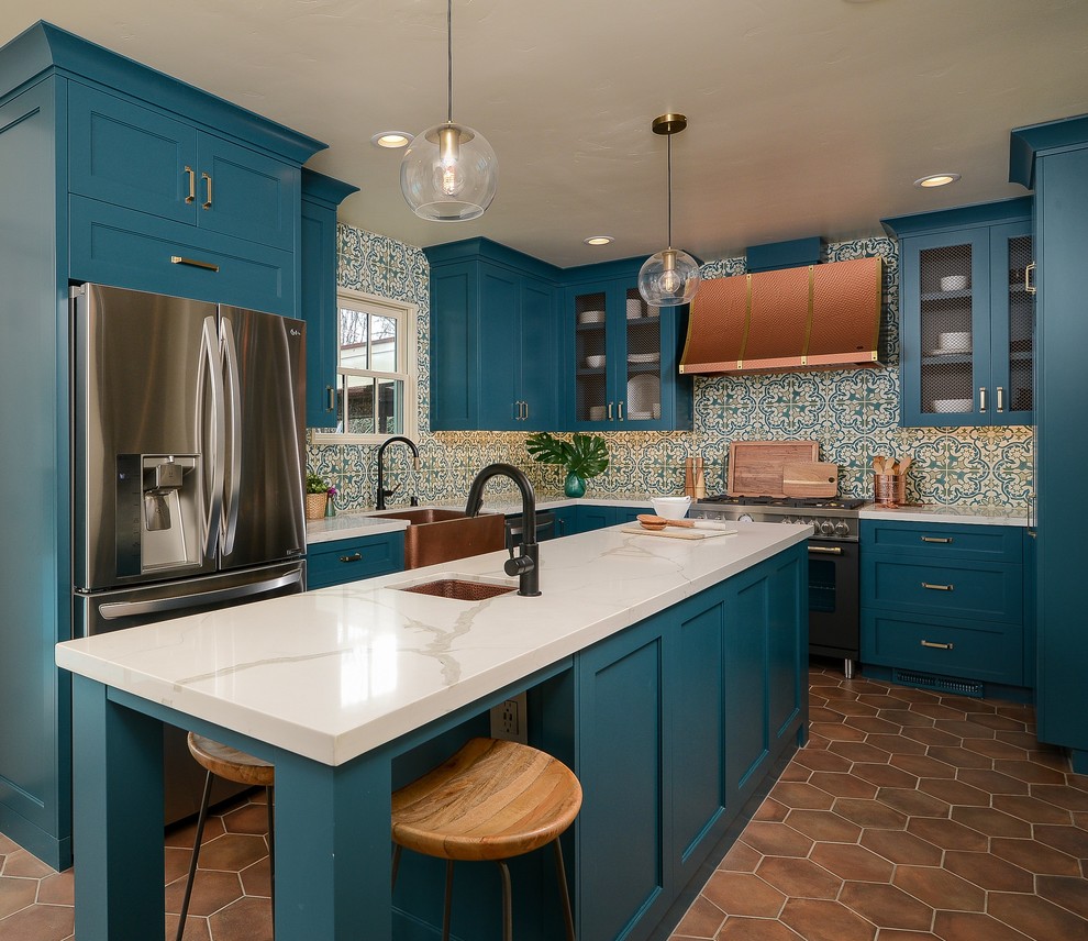 This is an example of a mediterranean kitchen in Sacramento with shaker cabinets, turquoise cabinets, solid surface benchtops, terra-cotta floors, with island and white benchtop.