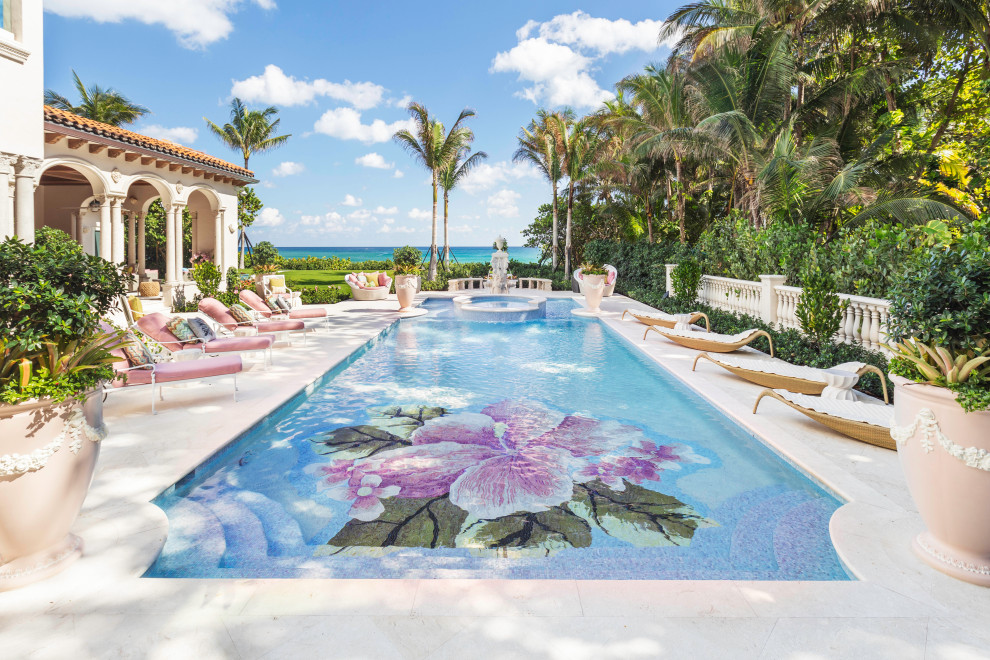 Large mediterranean backyard custom-shaped pool in Miami with a hot tub and tile.