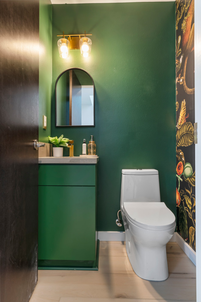 This is an example of a medium sized retro shower room bathroom in Seattle with flat-panel cabinets, green cabinets, a one-piece toilet, green walls, vinyl flooring, a built-in sink, marble worktops, beige floors, grey worktops, a single sink, a built in vanity unit, an enclosed toilet and wallpapered walls.