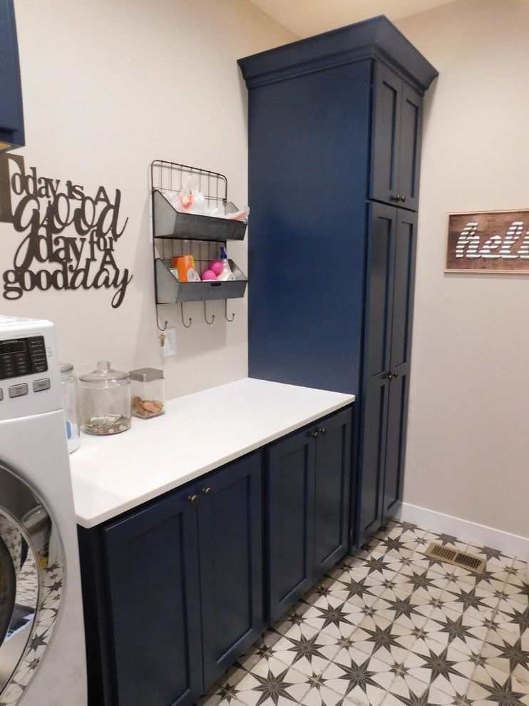 Photo of a midcentury galley utility room in Other with flat-panel cabinets, blue cabinets, quartz benchtops, porcelain floors and a side-by-side washer and dryer.
