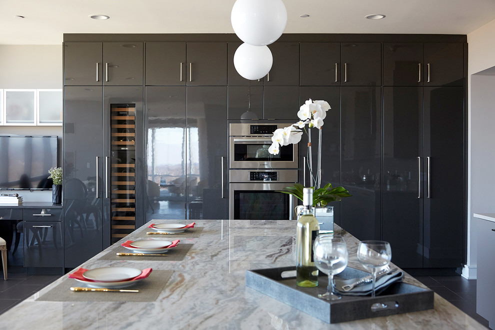 Inspiration for an expansive contemporary u-shaped eat-in kitchen in New York with an undermount sink, flat-panel cabinets, grey cabinets, quartz benchtops, grey splashback, glass tile splashback, stainless steel appliances, porcelain floors, with island, grey floor and multi-coloured benchtop.