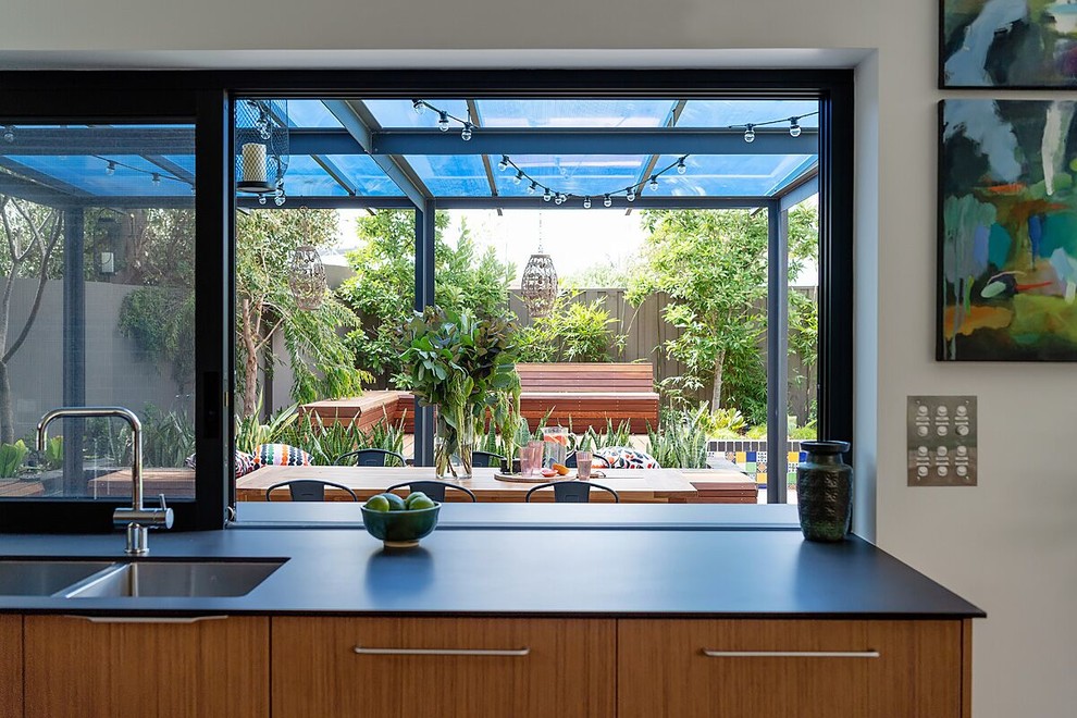 Photo of a midcentury open plan kitchen in Perth with a double-bowl sink, flat-panel cabinets, medium wood cabinets, laminate benchtops and with island.