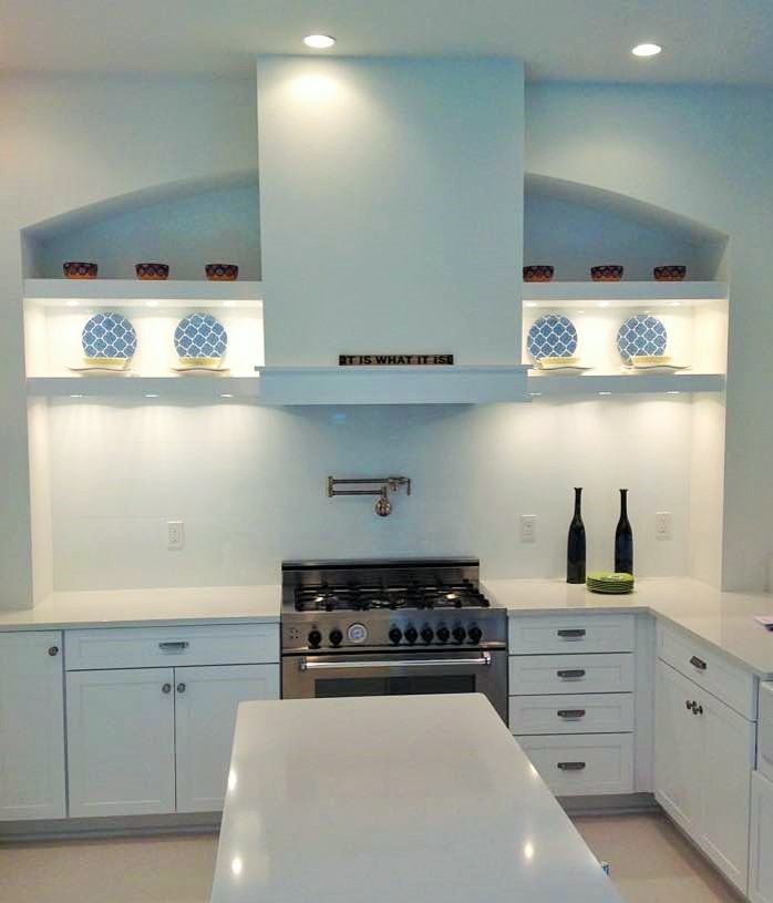 This is an example of a mid-sized contemporary u-shaped kitchen pantry in Miami with a farmhouse sink, shaker cabinets, white cabinets, quartz benchtops, stainless steel appliances, with island and ceramic floors.
