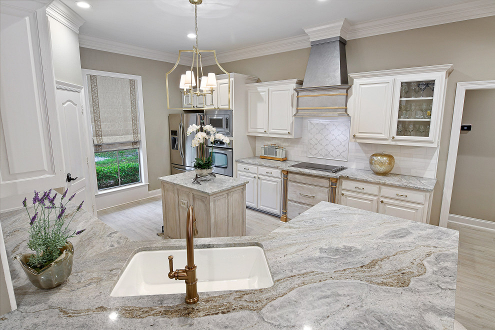 Inspiration for a mid-sized transitional porcelain tile and gray floor eat-in kitchen remodel with an undermount sink, raised-panel cabinets, white cabinets, granite countertops, white backsplash, marble backsplash, stainless steel appliances, an island and multicolored countertops