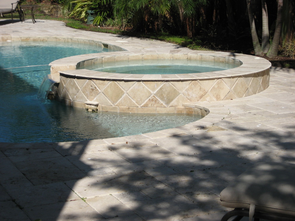 Inspiration for a large mediterranean backyard custom-shaped pool in Miami with a hot tub and tile.