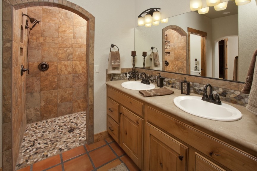 Inspiration for a master bathroom in Denver with a drop-in sink, raised-panel cabinets, medium wood cabinets, a double shower, terra-cotta tile, beige walls and terra-cotta floors.