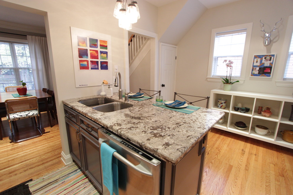 Photo of a mid-sized eclectic l-shaped separate kitchen in Toronto with an undermount sink, raised-panel cabinets, white cabinets, granite benchtops, white splashback, subway tile splashback, stainless steel appliances, light hardwood floors and a peninsula.