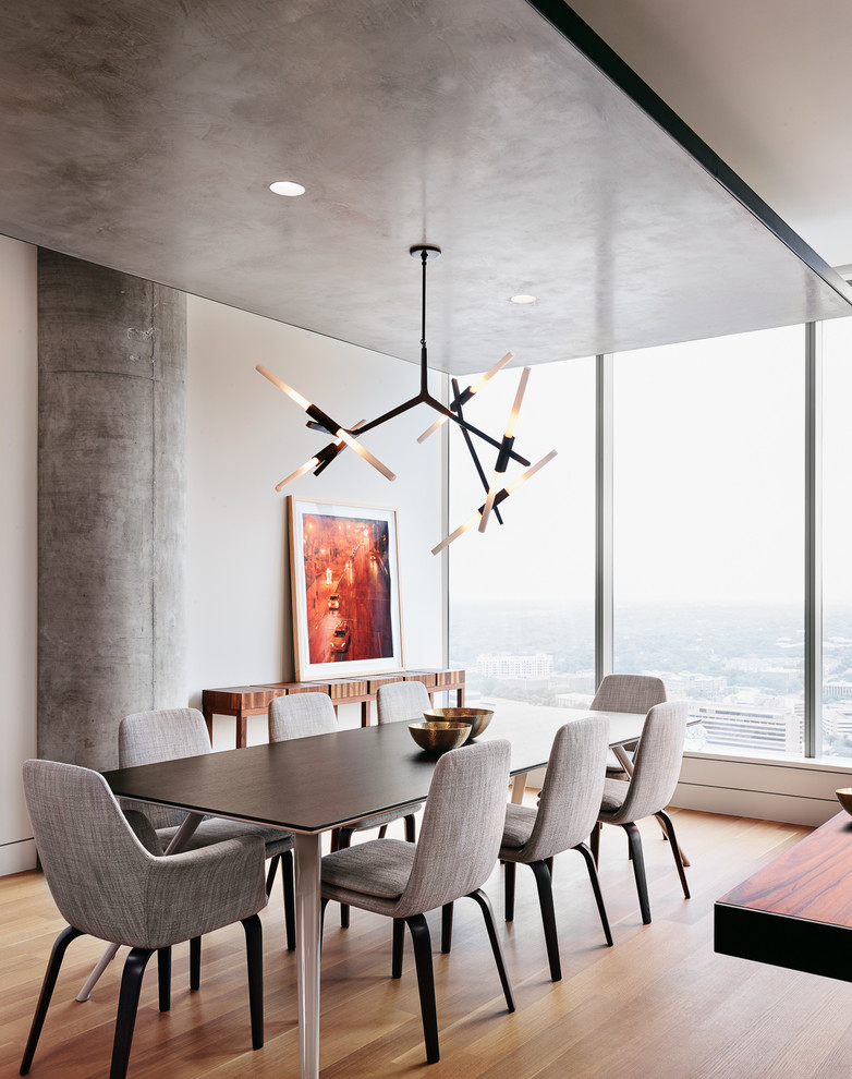 This is an example of a contemporary dining room in Austin with beige walls, light hardwood floors and beige floor.