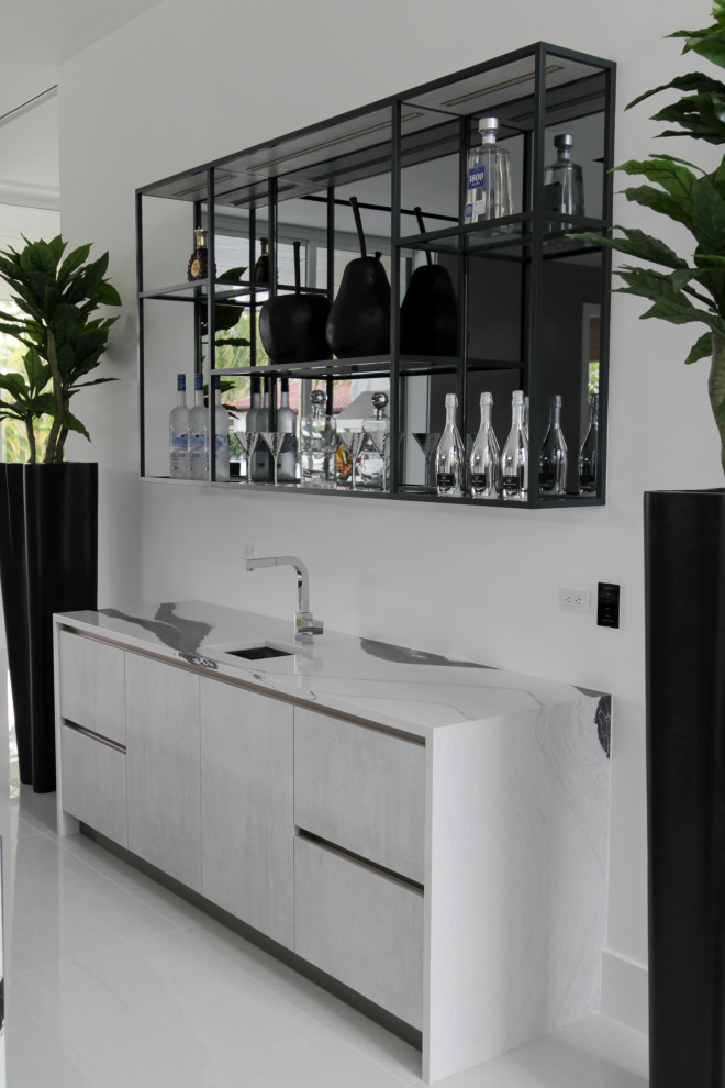 Design ideas for a mid-sized contemporary galley seated home bar in Miami with an undermount sink, flat-panel cabinets, grey cabinets, quartz benchtops, ceramic floors, white floor and white benchtop.