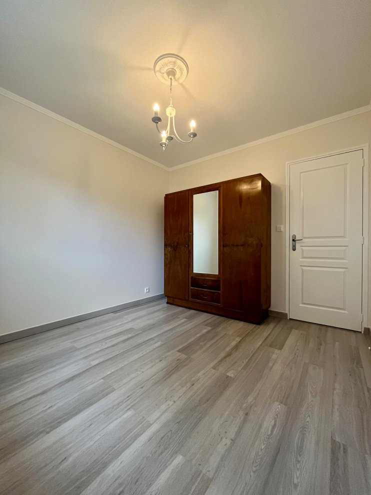 Mid-sized traditional guest bedroom in Nantes with beige walls, laminate floors, no fireplace and grey floor.