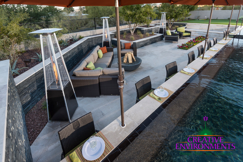 Home design - huge modern backyard stamped concrete and custom-shaped infinity home design idea in Phoenix