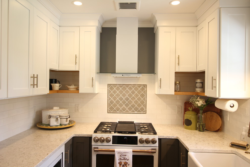 Enclosed kitchen - mid-sized transitional u-shaped medium tone wood floor and brown floor enclosed kitchen idea with a farmhouse sink, shaker cabinets, white cabinets, quartz countertops, white backsplash, subway tile backsplash, white appliances, no island and beige countertops