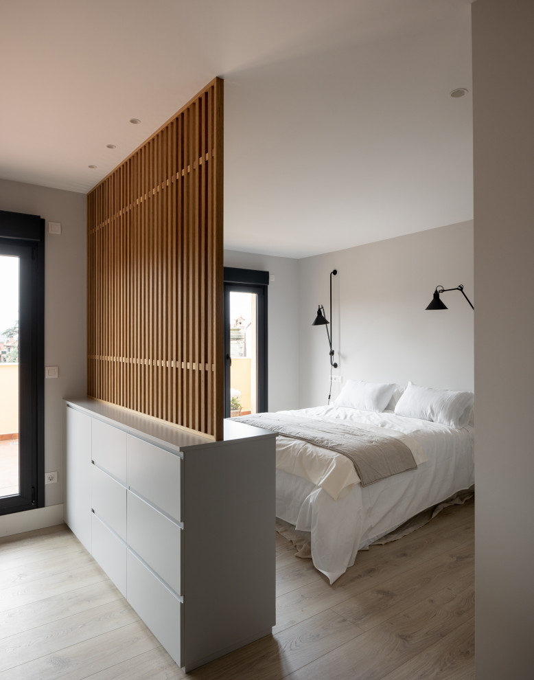 Стильный дизайн: большая хозяйская спальня в белых тонах с отделкой деревом в стиле модернизм с серыми стенами, полом из ламината и коричневым полом без камина - последний тренд