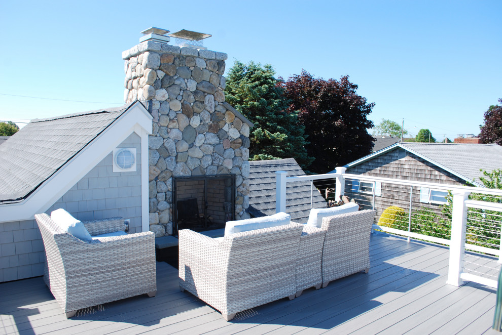 This is an example of a medium sized nautical roof rooftop wire cable railing terrace in Providence with a fireplace and no cover.