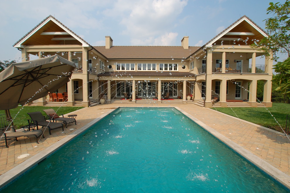 Example of a huge transitional backyard brick and rectangular lap pool fountain design in Baltimore