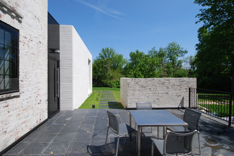 Inspiration for a contemporary patio in St Louis with natural stone pavers and no cover.