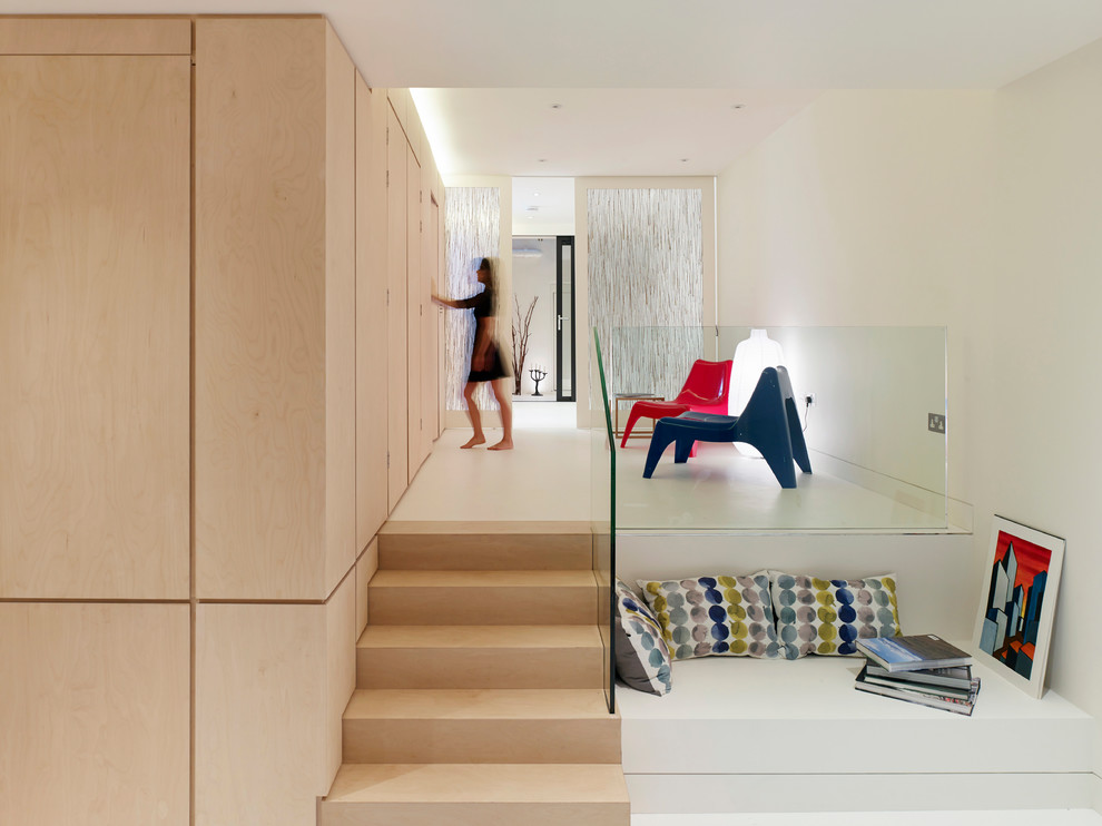 This is an example of a contemporary fully buried basement in London with white walls and white floor.