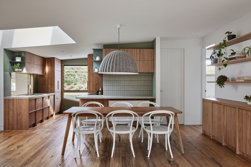 Cette photo montre une salle à manger ouverte sur la cuisine bord de mer de taille moyenne avec un sol en bois brun.