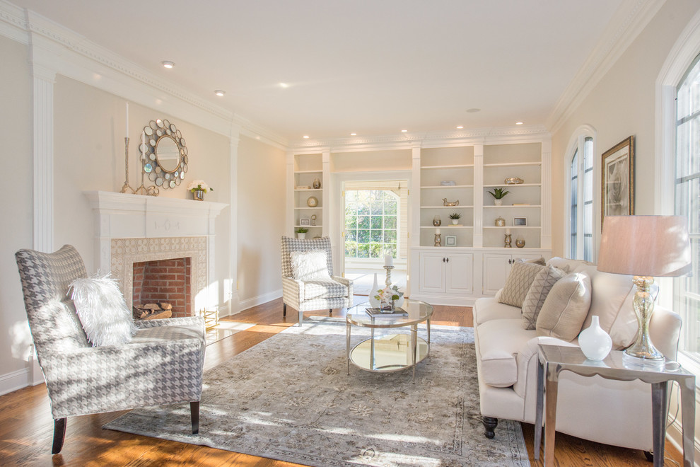 This is an example of a transitional formal enclosed living room in New York with medium hardwood floors, a standard fireplace, a brick fireplace surround and no tv.
