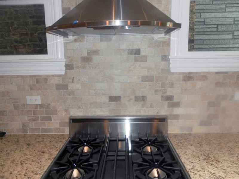 Kitchen - transitional kitchen idea in Chicago with granite countertops, beige backsplash, stone tile backsplash and stainless steel appliances