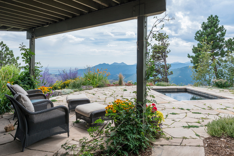 This is an example of a small country backyard rectangular pool in Denver with natural stone pavers.