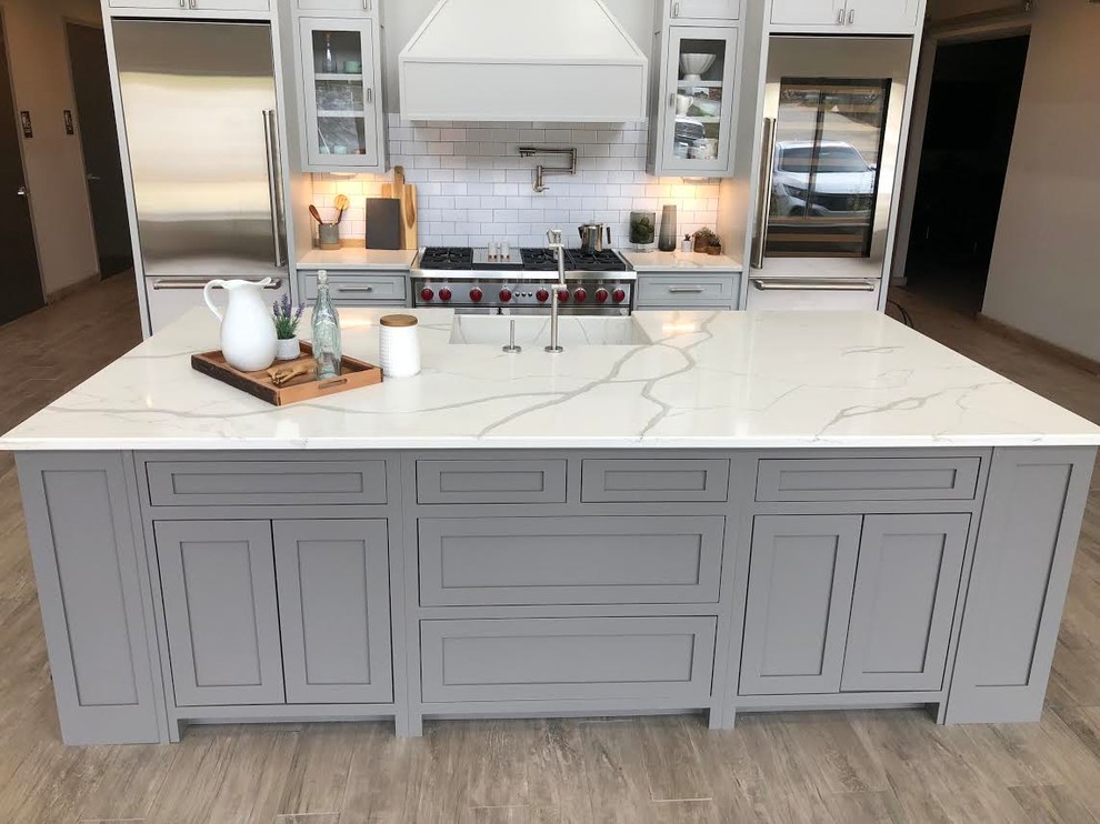 Design ideas for a mid-sized country u-shaped eat-in kitchen in Atlanta with an integrated sink, recessed-panel cabinets, grey cabinets, quartzite benchtops, white splashback, subway tile splashback, stainless steel appliances, with island and white benchtop.