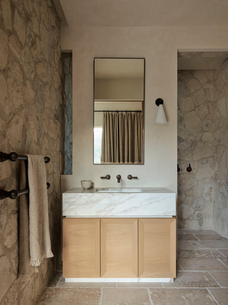Expansive transitional bathroom in Sydney with stone tile, a built-in vanity, flat-panel cabinets, light wood cabinets, beige walls, an undermount sink, beige floor, white benchtops and a single vanity.