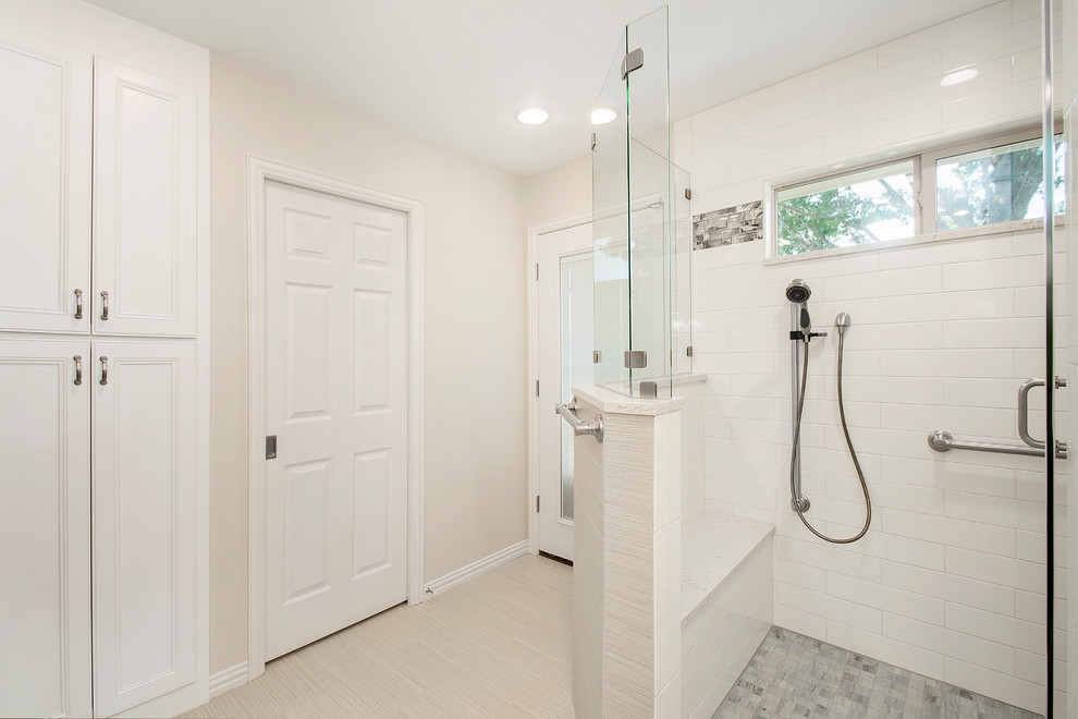 This is an example of a mid-sized transitional master bathroom in Dallas with shaker cabinets, white cabinets, a corner shower, a two-piece toilet, white tile, ceramic tile, beige walls, porcelain floors, an undermount sink, engineered quartz benchtops, beige floor and a hinged shower door.