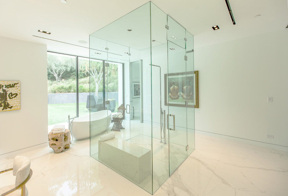 Expansive contemporary master bathroom in Los Angeles with flat-panel cabinets, light wood cabinets, a freestanding tub, an open shower, a one-piece toilet, white tile, stone slab, white walls, marble floors, a drop-in sink and marble benchtops.