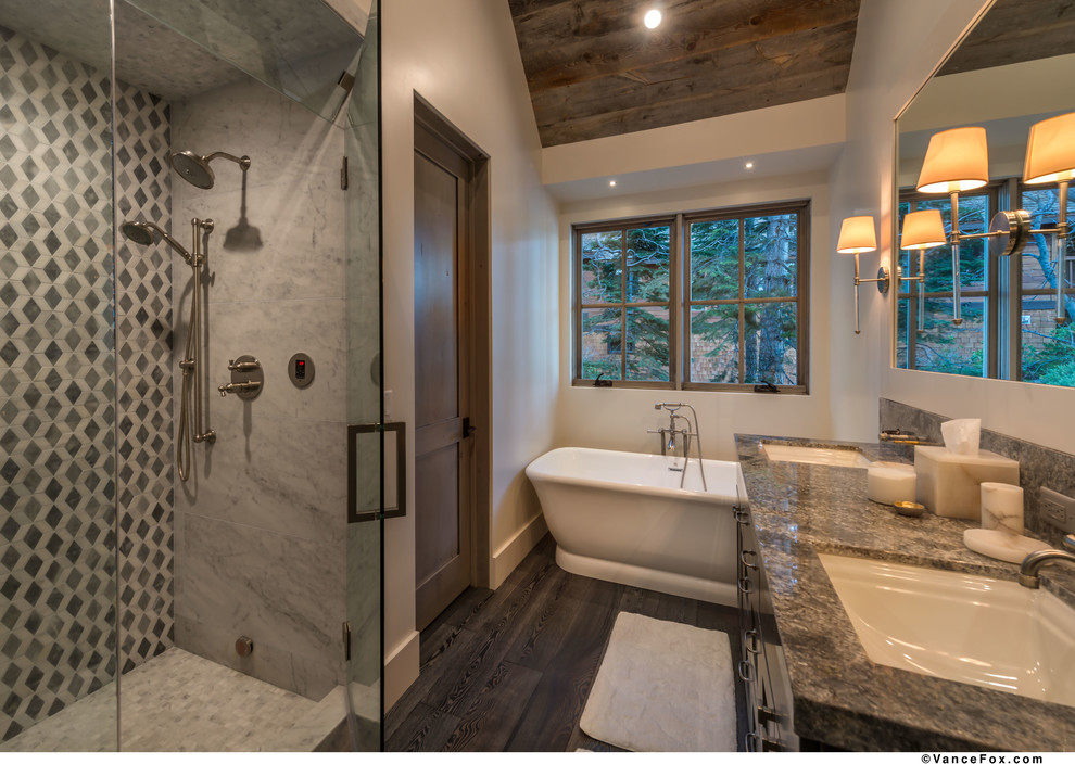 Design ideas for a mid-sized country master bathroom in Sacramento with shaker cabinets, a freestanding tub, a corner shower, grey walls, dark hardwood floors, an undermount sink, granite benchtops, grey floor, a hinged shower door and brown cabinets.