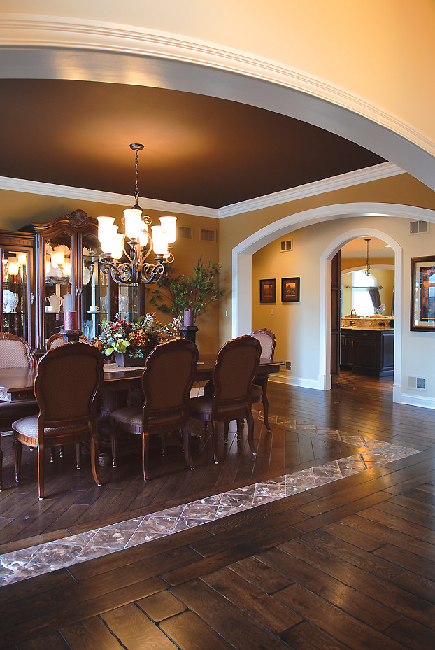 Inspiration pour une grande salle à manger ouverte sur la cuisine traditionnelle avec un mur orange, parquet foncé et un sol marron.