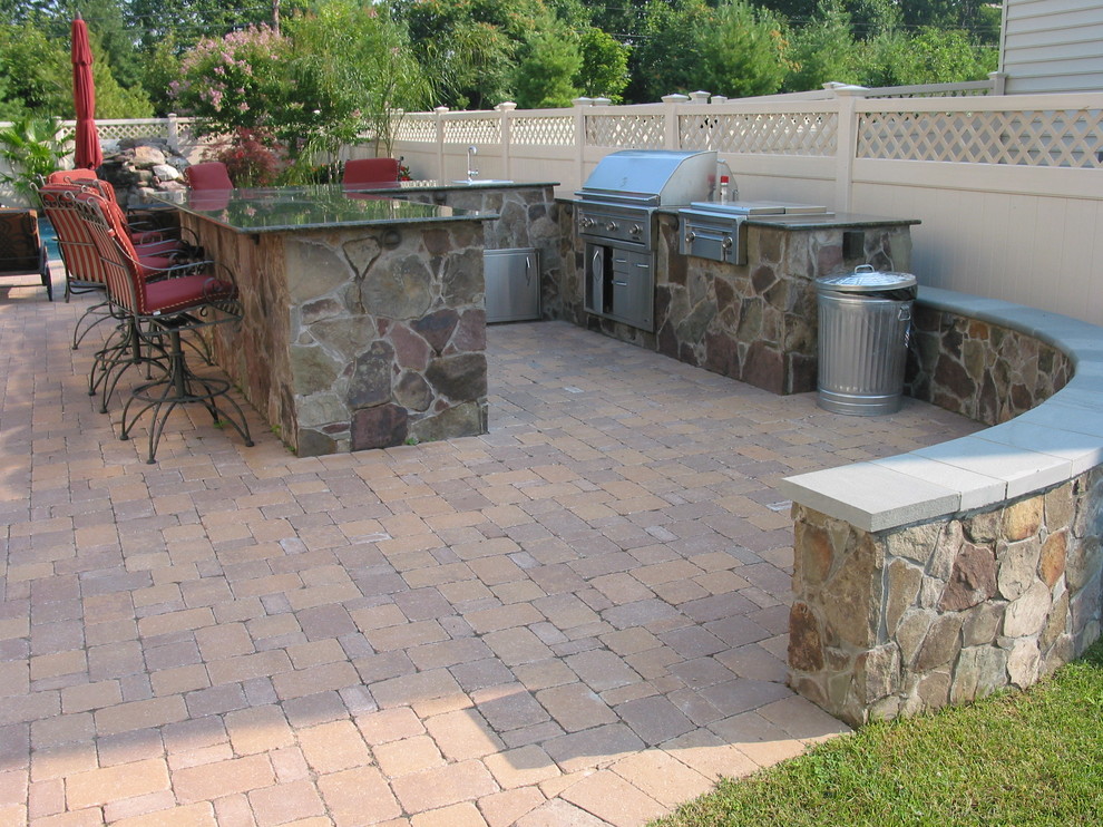 Mid-sized traditional backyard patio in Baltimore with concrete pavers and a water feature.