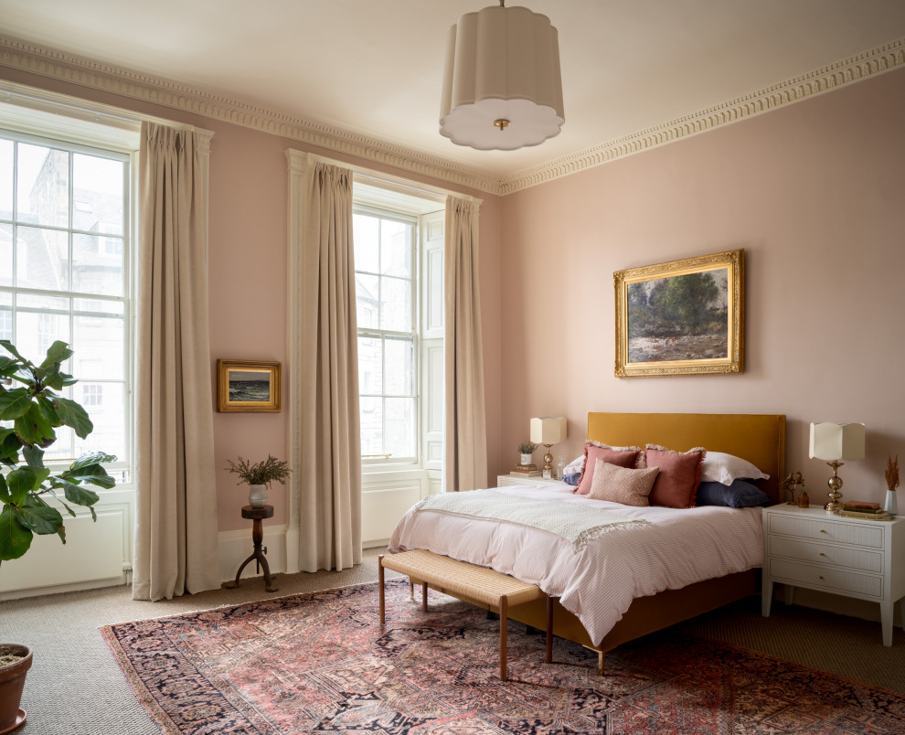 Large transitional master bedroom in Edinburgh with pink walls, carpet and grey floor.