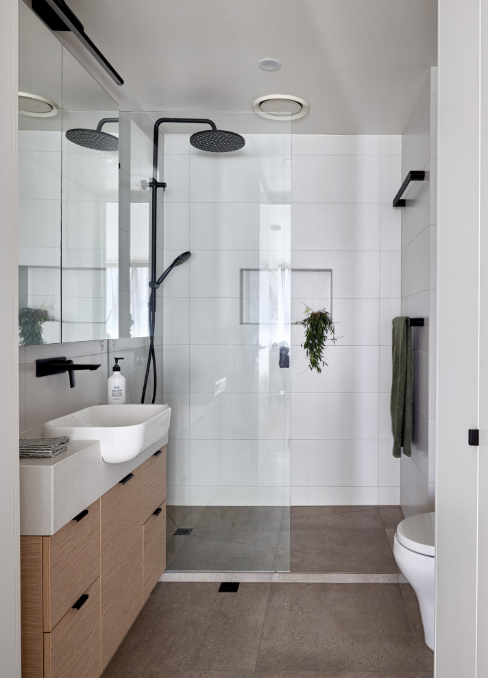 Example of a small trendy 3/4 white tile and ceramic tile ceramic tile, gray floor and single-sink bathroom design in Melbourne with flat-panel cabinets, light wood cabinets, a one-piece toilet, white walls, a wall-mount sink, quartzite countertops, white countertops, a niche and a freestanding vanity