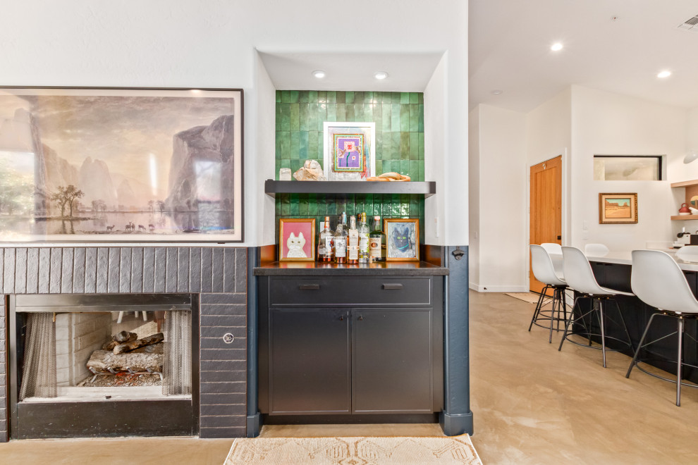 Midcentury home bar in Phoenix with shaker cabinets, black cabinets, granite benchtops, green splashback, concrete floors and black benchtop.